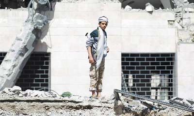 A Houthi militant inspects whot remains of a hotel destroyed in an air-strike by Saudi-led coalitions on Sunday.