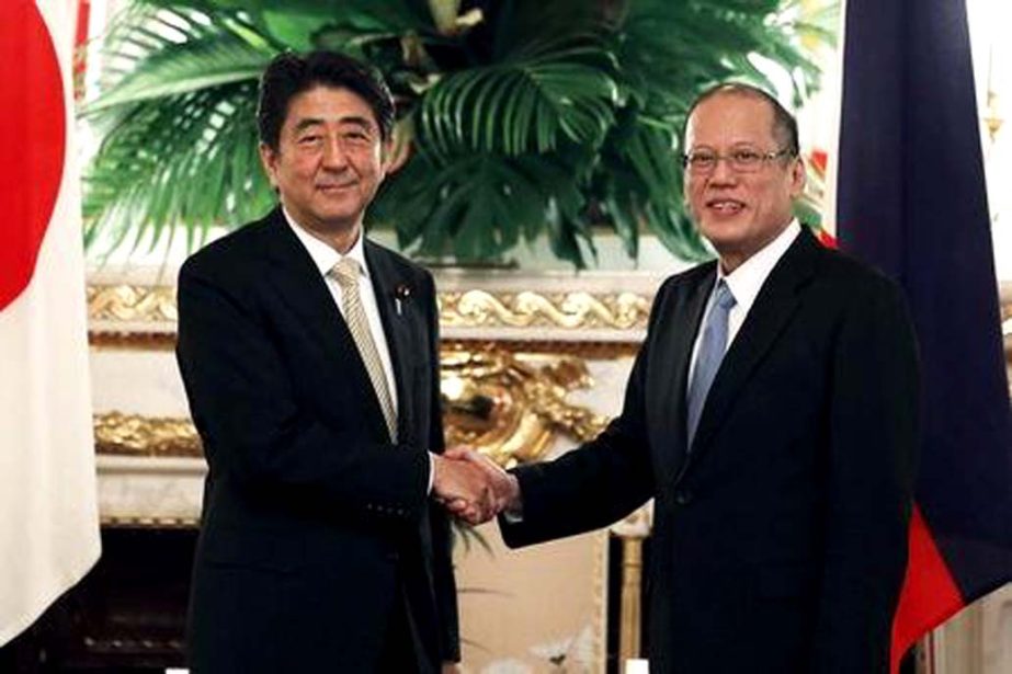 Philippine President Benigno Aquino (R) shakes hands with Japanese Prime Minister Shinzo Abe before their meeting at Akasaka Palace state guest house in Tokyo on Thursday.