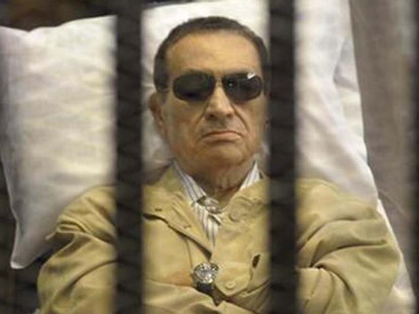 Egypt's former president Hosni Mubarak sits inside a case in courtroom in Cairo.