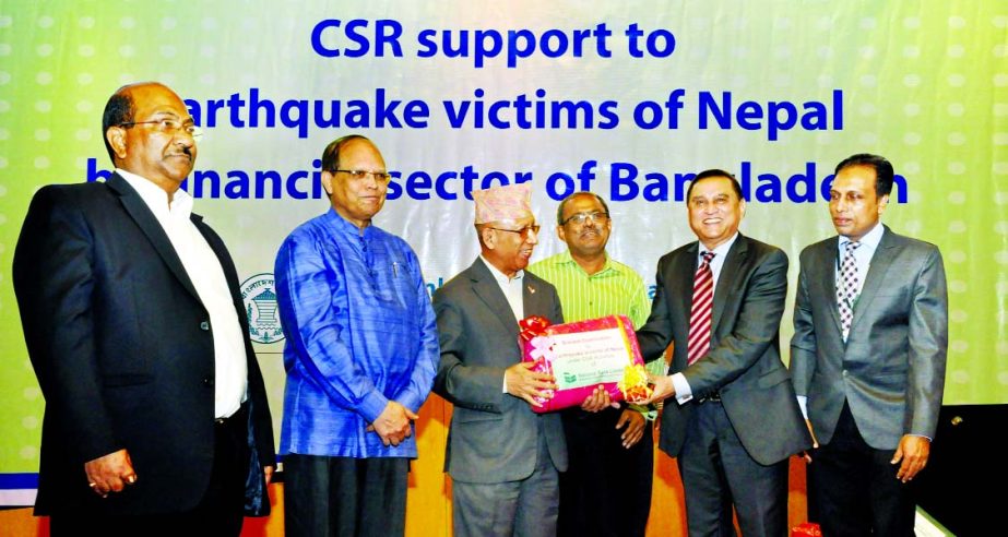 Nepal Ambassador Hari Kumar Shrestha receiving cash and kind from Shamsul Huda Khan, Managing Director of National Bank Ltd, for Nepal's earthquake victims at a city hotel recently. BB Governor Dr Atiur Rahman, Deputy Governor SK Sur Chowdhury and Execu