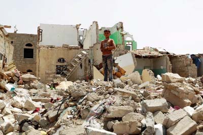 A Yemeni boy stands amidst the rubble of houses destroyed by Saudi-led air strike on a residential area last month, in the capital Sanaa.