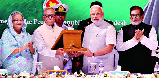 Indian Prime Minister Narendra Modi on behalf of Indian ex-Prime Minister Atal Bihari Vajpayee receiving award from President Abdul Hamid at a ceremony held at Bangabhaban on Sunday for his active role during the War of Liberation of Bangladesh. BSS Phot