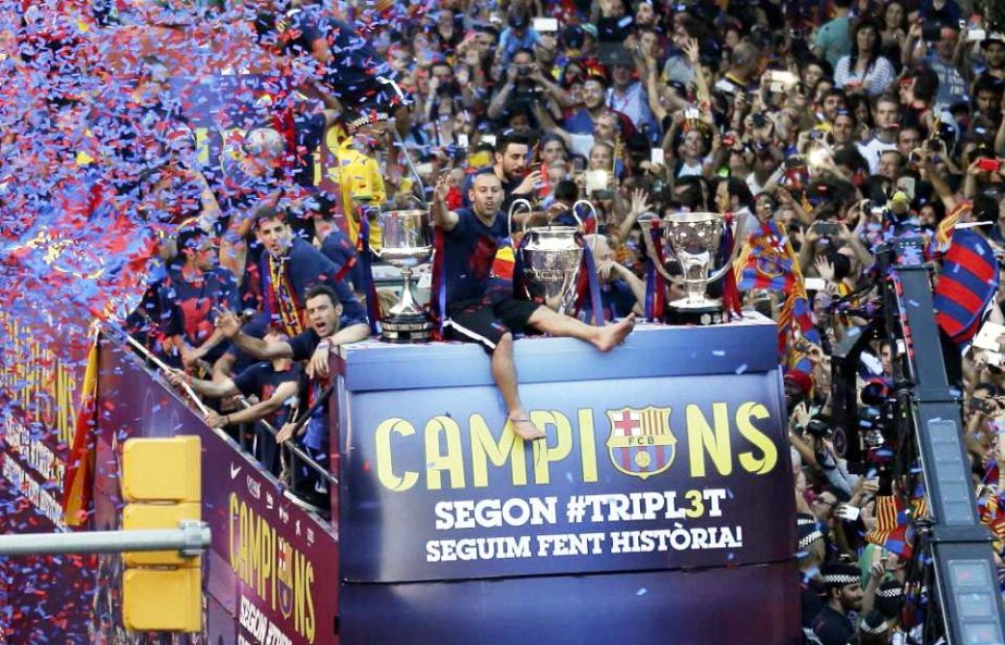 Barcelona's Javier Mascherano sits between the three trophies as he rides on the team bus during celebrations in Barcelona, Spain on Sunday after winning the Champions League final soccer match Saturday by beating Juventus Turin 3-1. Barcelona won the tr