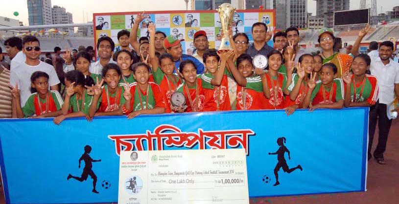 Players of Mymensingh Kalsindur Govt. Primary School pose with the trophy of Bangamata Begum Fazilatunnessa Mujib Gold Cup Primary School Football tournament at Bangabandhu National Stadium on Monday.