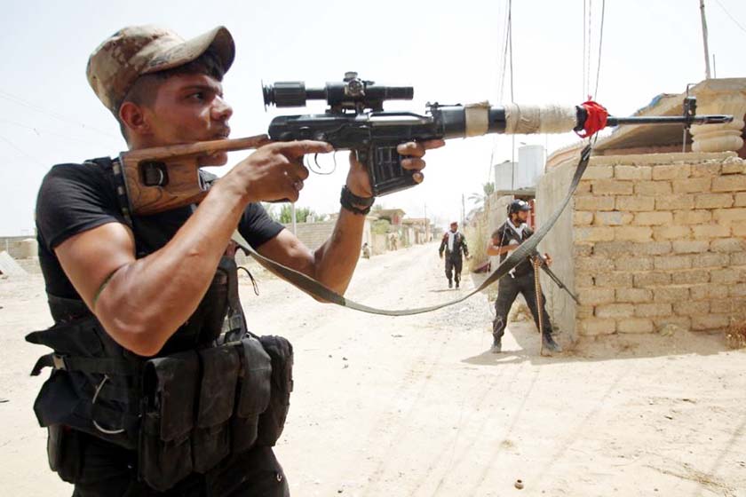 Iraqi Shiite fighters from the Popular Mobilisation force keep position during a battle against jihadists from the Islamic State group to retake the strategic town Baiji, north of Tikrit.