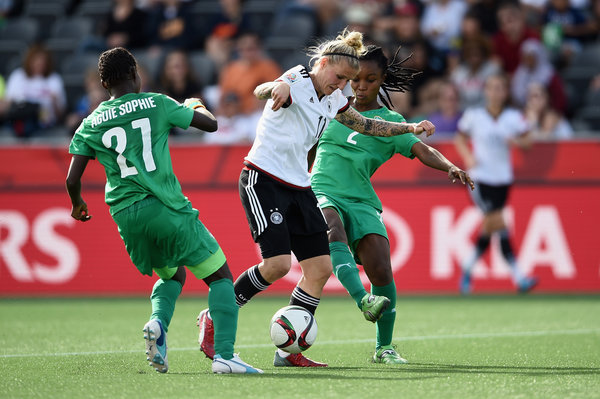 Anja Mittag of Germany was challenged by Sophie Aguie and Fatou Coulibaly of Ivory Coast in a game won by Germany, 10-0, on Sunday.