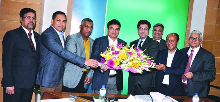 Sheikh Fazle Noor Taposh, MP, Chairman of Modhumoti Bank Limited, presenting bouquet to Md Ismail Hossain, Director of the bank and Managing Director of Sharmin Group for being elected Director of FBCCI recently. Meghna Group Chairman Mostafa Kamal, Labi