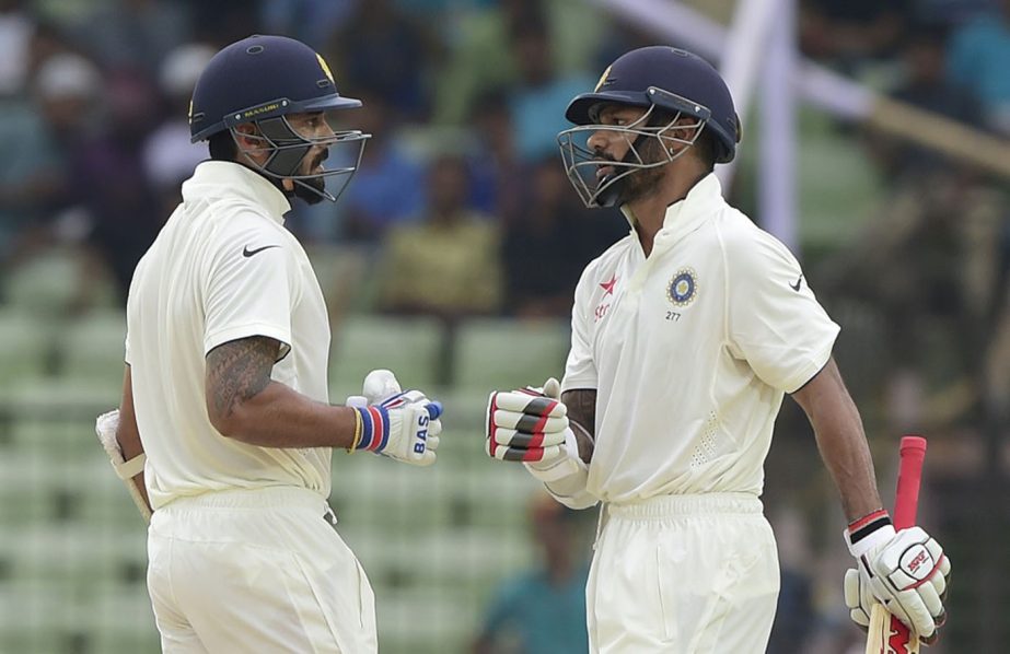 Indian cricketer Shikhar Dhawan (R) celebrates with teammate Murali Vijay after hitting a boundary during the first day of the first cricket Test match between Bangladesh and India at Khan Shaheb Osman Ali Stadium in Narayanganj on Wednesday.