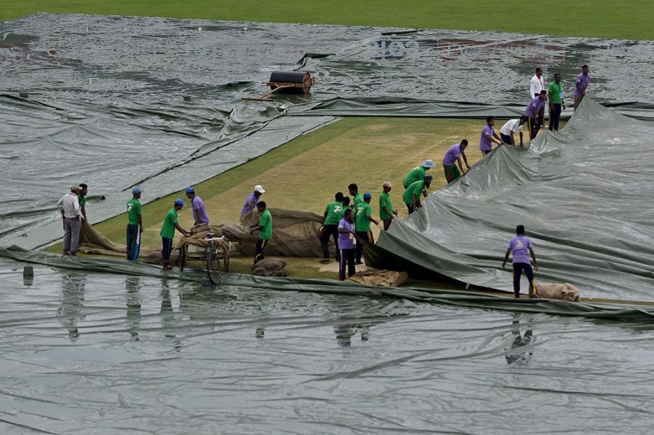 Bangladeshi ground staff cover the playing field as rain comes during the second day of the only cricket Test match between Bangladesh and India at Khan Shaheb Osman Ali Stadium in Narayanganj on Thursday.