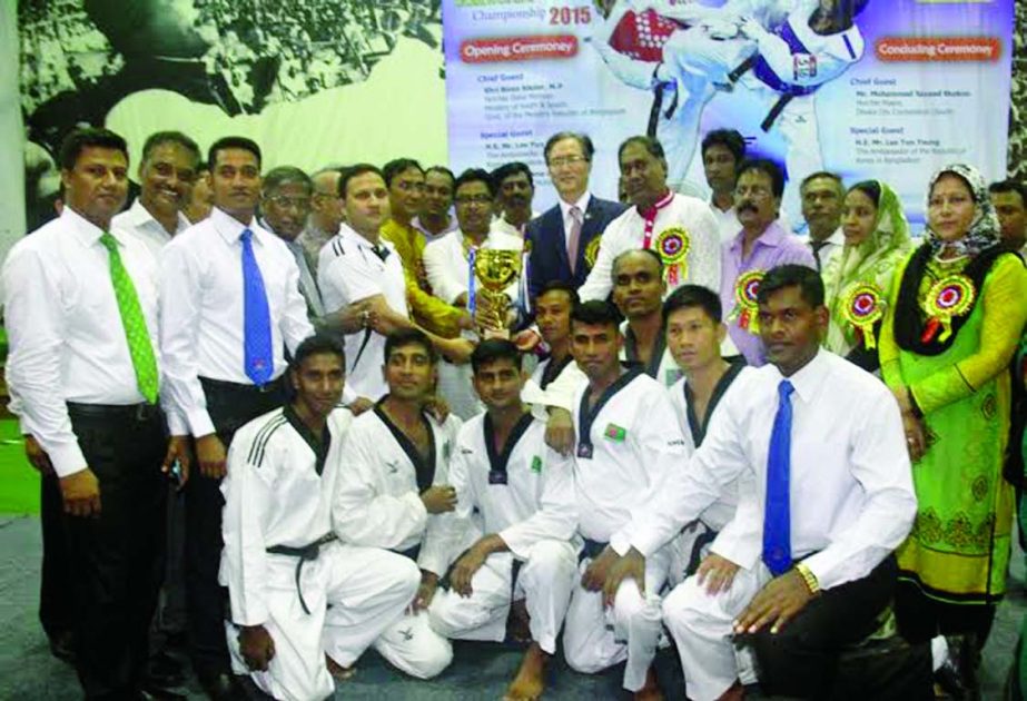 Bangladesh Army, the champions of the Senior Men's Division of the Korea Ambassador Cup Taekwondo Championship with the guests and officials of Bangladesh Taekwondo Federation at the Gymnasium of National Sports Council on Friday.