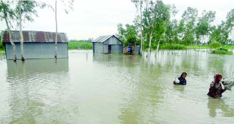 BOGRA: Two women going to a safer shelter as their houses were submerged due to dam collapse in Jamuna River. This picture was taken from Naokhila area in Sariakandi Upazila on Friday.
