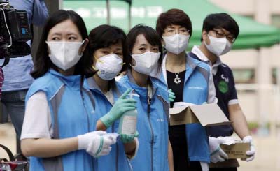 South Korean health workers from a community health center wearing masks as a precaution against MERS, Middle East Respiratory Syndrome, virus, wait to check examinees' temperature and to sanitize their hands at a test site for a civil service examinatio