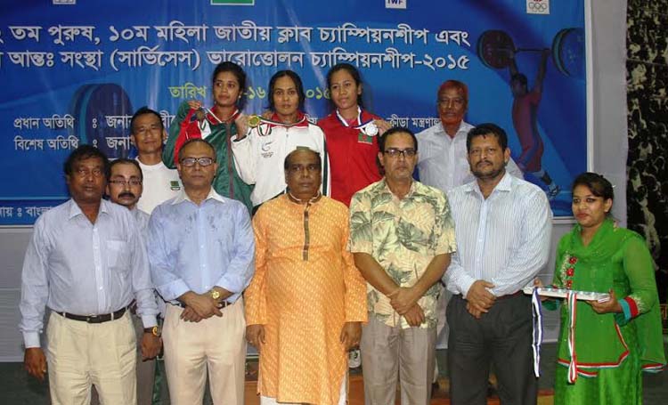 The winners of the 10th Women's National Club Championship with the guests and the officials of Bangladesh Weightlifting Federation pose for a photo session at the Gymnasium of National Sports Council on Sunday.