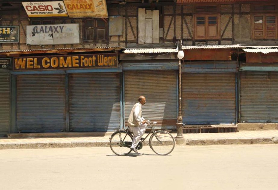 A Kashmiri civilian rides on his bicycle through a closed market during a strike in Srinagar, Indian controlled Kashmir, on Wednesday.