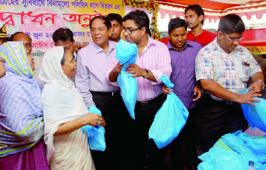 Mayor of Dhaka South City Corporation Syed Khokan distributing poly bags for collecting household waste at Mayor Hanif Community Centre in the city's Nazira Bazar on Wednesday.
