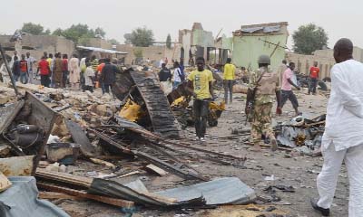 A curious crowed gathered in inspect the damaged after bomb blast in northeast Nigeria on Wednesday.