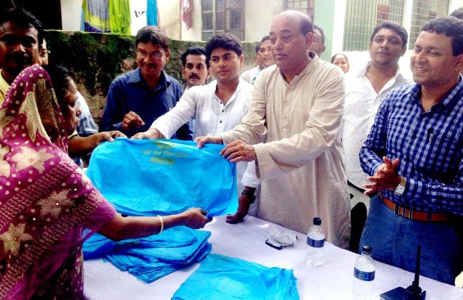Councillor of 26 No Ward of Dhaka South City Corporation (DSCC) Hasibur Rahman Manik distributing bags to dump waste at a ceremony organized by 14 No Ward of DSCC at Jhigatala in the city on Friday.