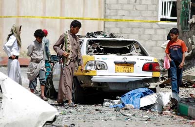 Yemenis observe the wreckage a day after five bombings targeting Shiite mosques and offices hit the capital Sanaa