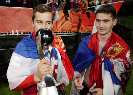 Serbia's Miladin Stevanovic kisses the trophy as he is watched by teammate Sasa Zdjelar, right, as they celebrate their 2-1 extra time win over Brazil in the U20 soccer World Cup final in Auckland, New Zealand on Saturday.