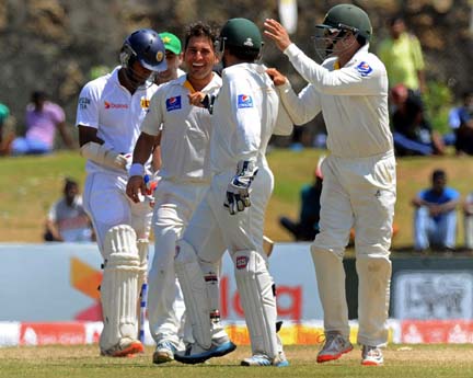 Yasir Shah celebrates Dimuth Karunaratne's wicket with his team-mates on the 5th day of 1st Test at Galle on Sunday.