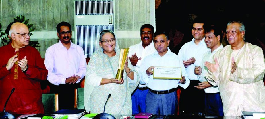 Prime Minister Sheikh Hasina receiving 'World Summit on the Information Society' Award from her Principal Secretary Abul Kalam Azad at the cabinet meeting on Monday. BSS photo