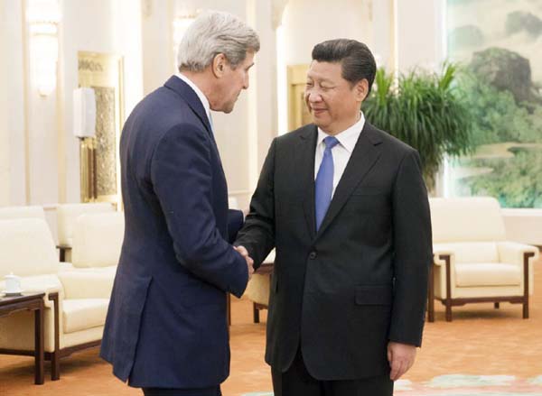 Chinese President Xi Jinping, right, and U.S. Secretary of State John Kerry shake hands prior to a meeting at the Great Hall of the People in Beijing, China.