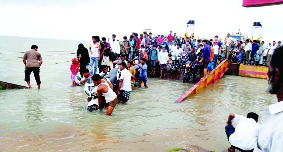 Ferry gangway at Amtoli in Barguna was inundated by flood water and causes immense sufferings to passengers. This photo was taken on Tuesday.