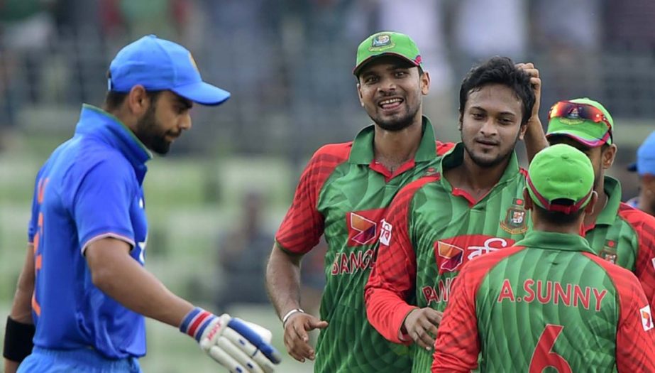 Bangladesh cricket captain Mashrafe Bin Mortaza (2L) congratulates teammate Shakib Al Hasan (3L) after the dismissal of Indian cricketer Virat Kohli (L) during the third ODI (One Day International) cricket match between Bangladesh and India at the Sher-e-