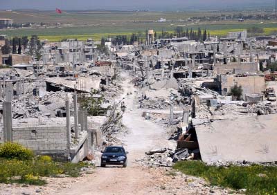 A car passes in an area that was destroyed during the battle between the U.S. backed Kurdish forces and the Islamic State fighters, in Kobani, north Syria.