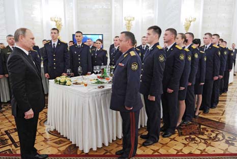 President Vladimir Putin, left, listens to a report during the Kremlin's meeting with graduates of Russian military academies, Moscow on Thursday.
