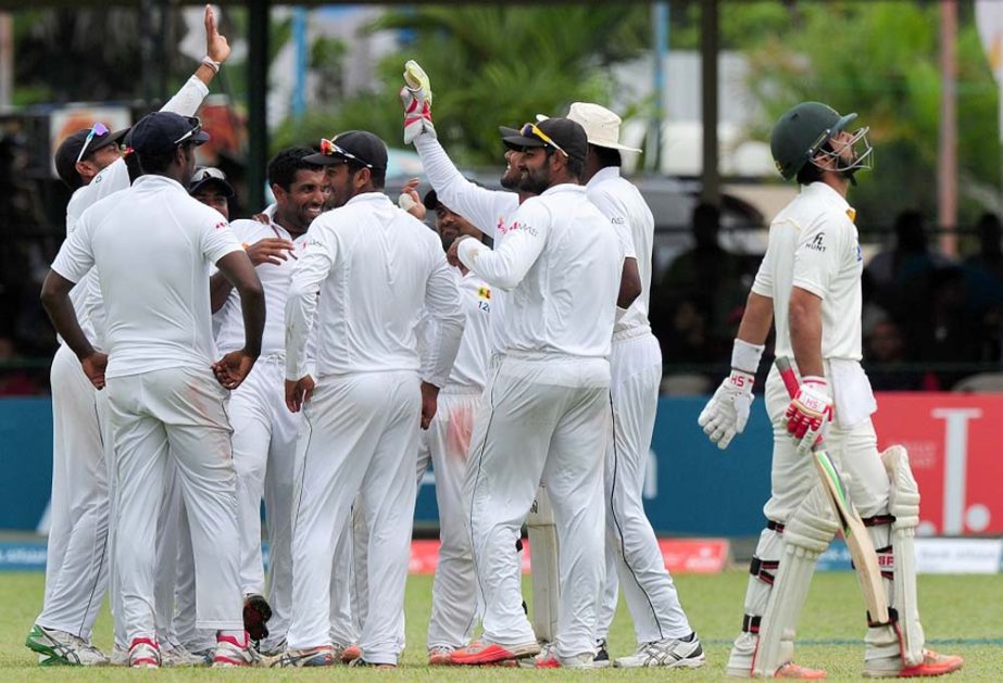 Pakistan cricketer Ahmed Shehzad (R) walks back to the pavilion after losing his wicket during the third day of the second Test match between Sri Lanka and Pakistan at the P. Sara Oval Cricket Stadium in Colombo on Saturday.