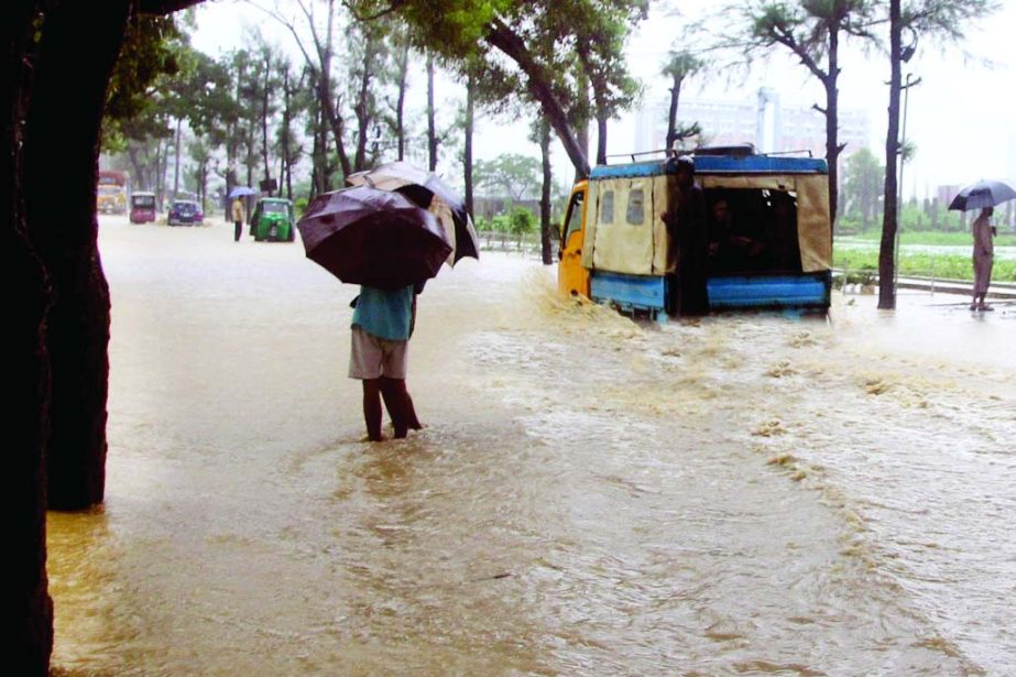 Low-lying areas of Kolatoli in Cox's Bazar sea front remained under knee-deep water from flash flood causing inconveniences to people. This photo was taken on Saturday.
