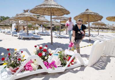 People lay flowers at the site of a shooting attack on the beach in front of the Riu Imperial Marhaba Hotel in Port el Kantaoui, on the outskirts of Sousse south of the capital Tunis