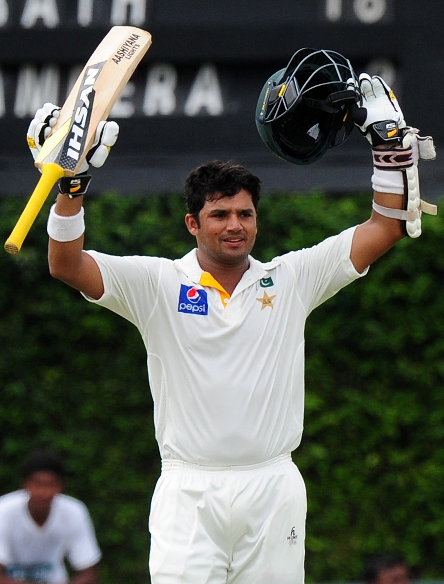 Pakistani cricketer Azhar Ali raises his bat and helmet in celebration after scoring a century during the fourth day of the second Test match between Sri Lanka and Pakistan at the P Sara Oval Cricket Stadium in Colombo on Sunday.