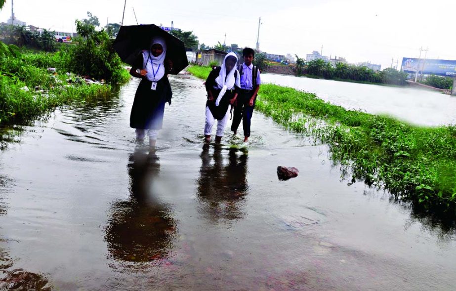 Students and residents of DND Dam, in the outskirts of the capital facing immense sufferings following inundation of vast areas by the ongoing monsoon rains. This photo was taken on Sunday.
