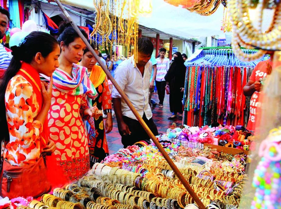 Women of all ages crowded the makeshift market at footpath to choose imitation ornaments. This photo was taken from New Market area on Monday.