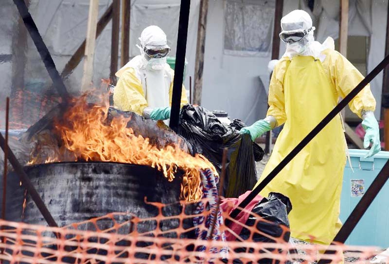 Health workers burn clothes belonging to Ebola patients at a medical centre in the Liberian capital Monrovia.
