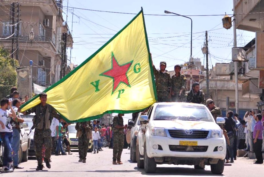 Kurdish People's Protection Units (YPG) fighters parade in the northeastern Syrian town of Qamishli after returning from battling Islamic State (IS) group jihadists in Tal Abyad .