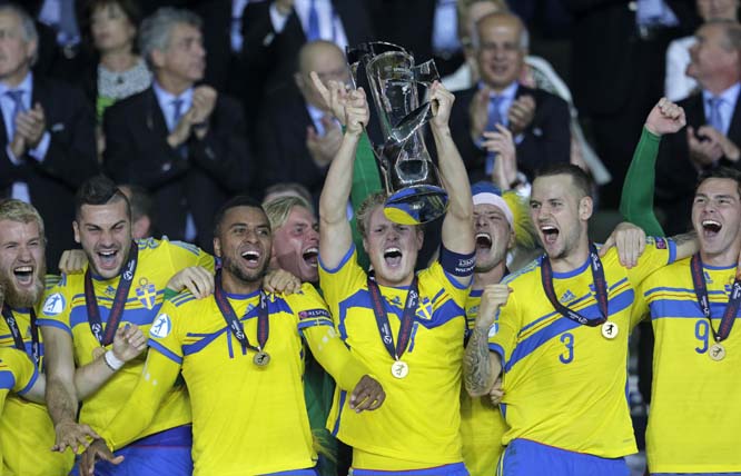 Sweden's Oscar Hiljemark raises the trophy in the (center) of his team after winning the Euro U21 soccer championship final match between Sweden and Portugal, at the Eden stadium in Prague, Czech Republic on Tuesday. Sweden defeated Portugal on penalties