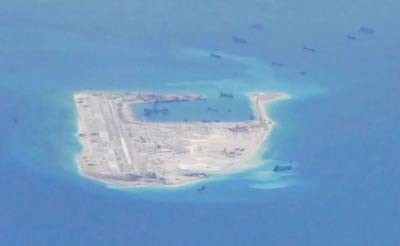 Chinese dredging vessels are purportedly seen in the waters around Fiery Cross Reef in the disputed Spratly Islands in this still image provided by the United States Navy.