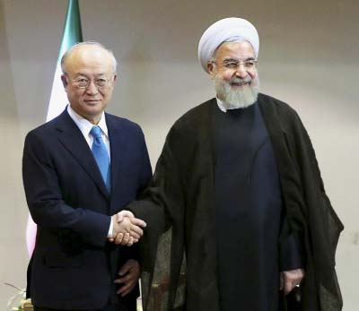 Iran's President Hassan Rouhani, right, shakes hands with the International Atomic Energy Agency's director-general, Yukiya Amano, as they pose for photos at the start of their meeting in Tehran, Iran on Thursday