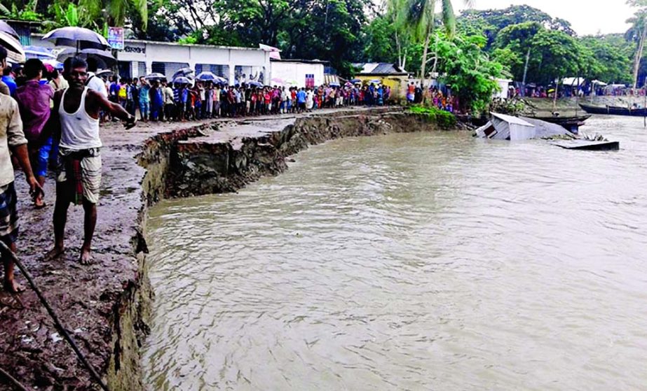 Hundreds of dismayed people watching the sudden erosion of Kirtankhola River in Barisal threatening Charkaua Bazar, UP office, school, madrasah, community clinic and other establishments on Friday.
