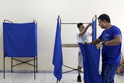 Men prepare voting booths ahead of the referendum at a high school, which will be used a polling station in Athens, Greece.
