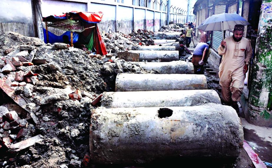 Road digging in the capital by various utility services including WASA is a regular feature during monsoon rains. Photo shows concrete sewerage slabs being kept on narrow lane blocking the thoroughfare, causing immense sufferings to local residents at Far