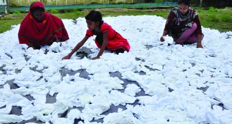 BOGRA: Women in Bogra are passing busy time to dry caps ahead of Eid. This picture was taken from Sherpur area on Wednesday.