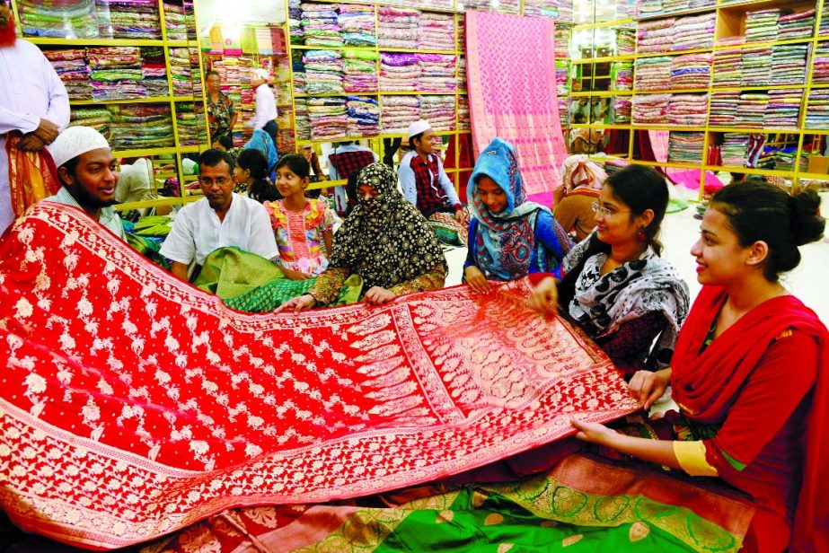 Eid shoppers are busy with their shopping spree at Hanif Silk, Benarasi Palli, Mirpur in the city on Friday. Shopkeeper demands Tk3 lakh and 70 thousand for this Benarasi sharee.