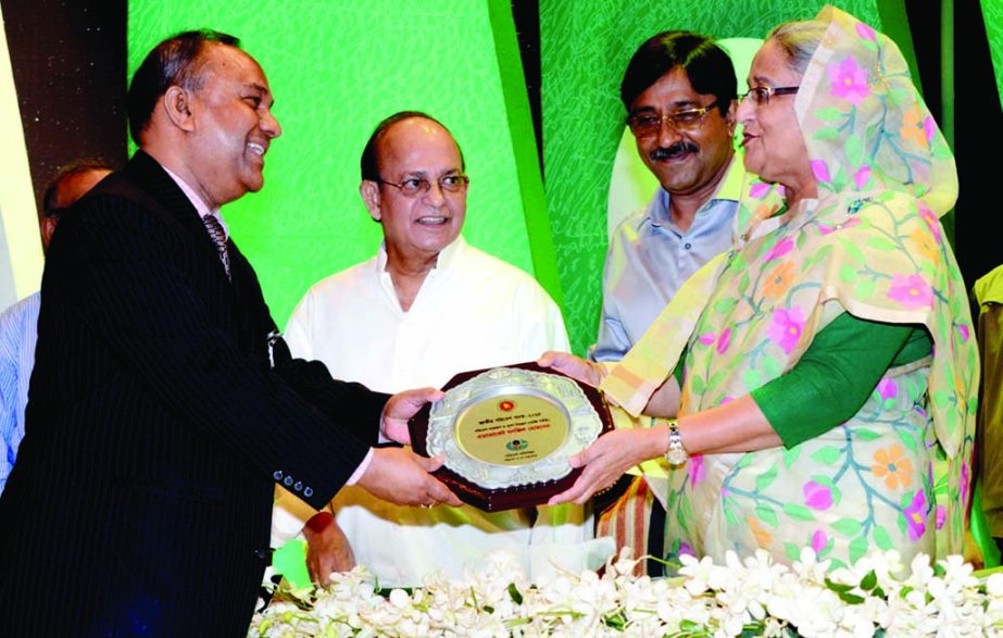 Prime Minister Sheikh Hasina handing over crest among the agriculturist at the inaugural ceremony of National Tree Plantation and its Mela '15 at Agricultural Institute auditorium on Sunday.