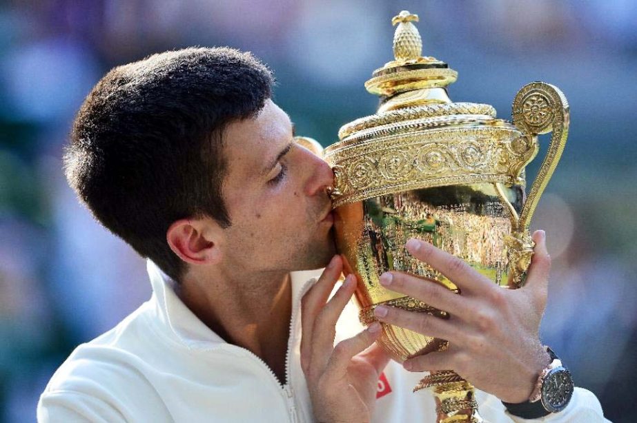 Serbia's Novak Djokovic kisses the winner's trophy after beating Switzerland's Roger Federer in the men's singles final match during the presentation ceremony on day thirteen of the 2014 Wimbledon Championships on Sunday.