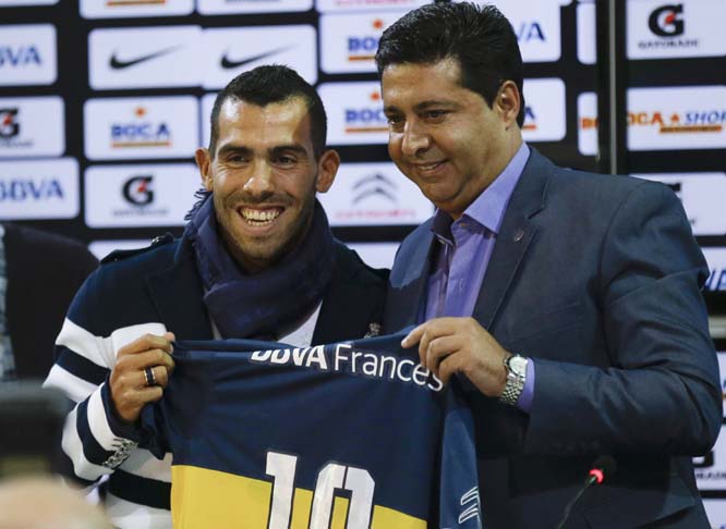 Boca Juniors' President Daniel Angelici (right) and Argentinaâ€™s striker Carlos Tevez pose for a picture with the club's t-shirt during his presentation as part of the team in Buenos Aires, Argentina on Monday. Juventus made Tevez's transfer to