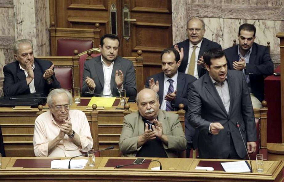 Members of the government applaud Greek Prime Minister Alexis Tsipras (R) as he delivers his speech during a parliament vote concerning Greece's proposal to the lenders, at the parliament in Athens, Greece.